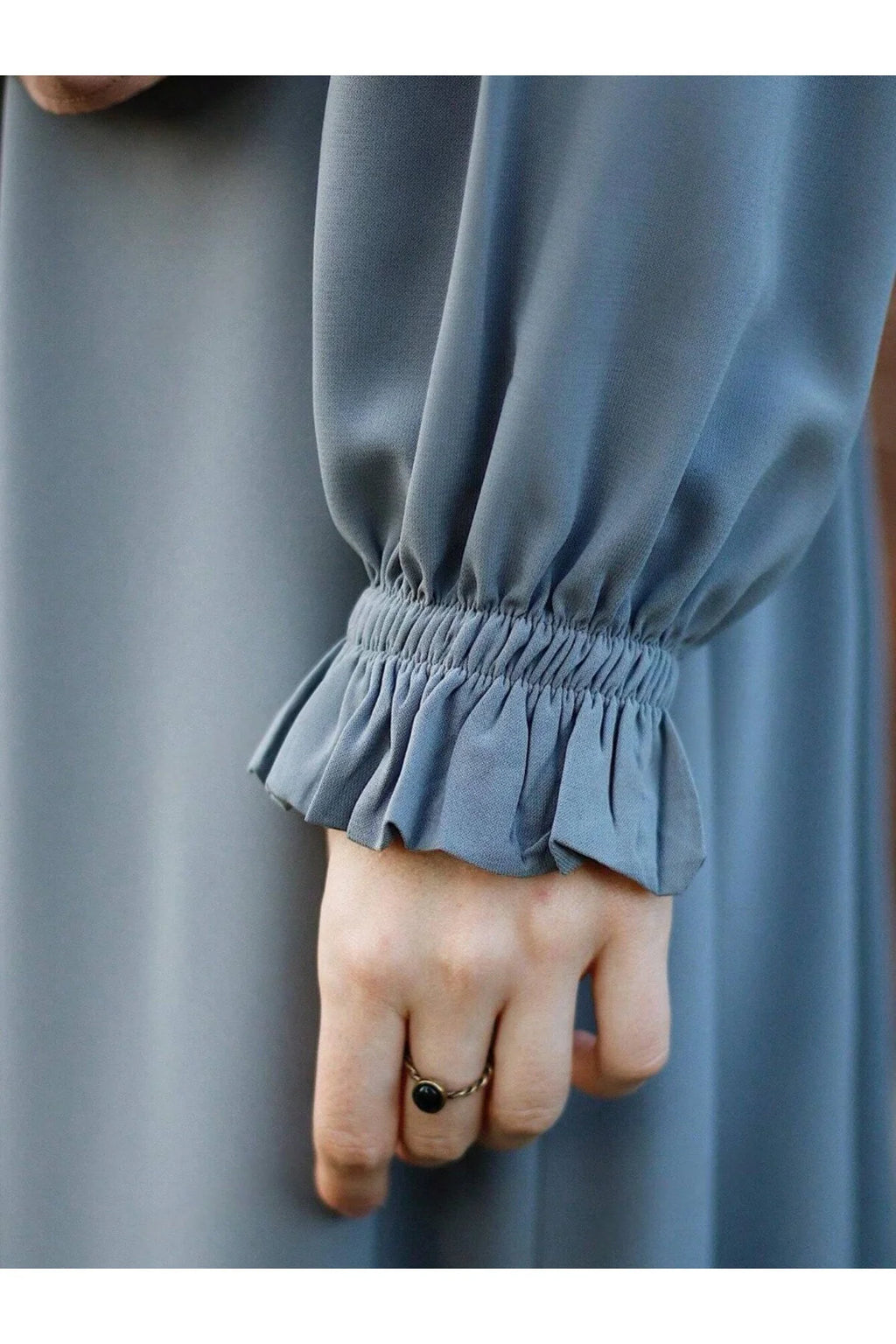 فستان بطبقات متعددة وطيات، بلونٍ سادة، مرن بأربع اتجاهات ومزيّن بالكشكش